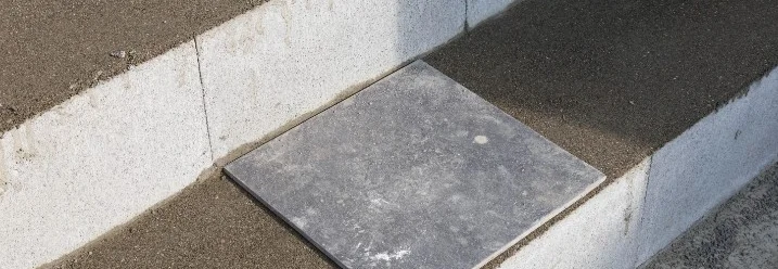 Fliese auf einer Treppenstufe während des Verlegens